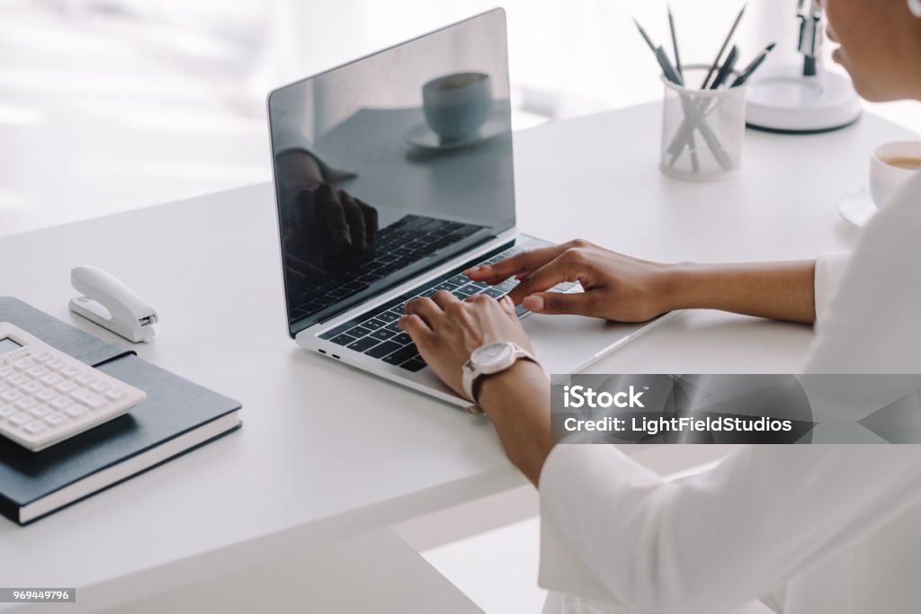 cropped image of african american businesswoman using laptop in workspace